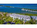 Aerial view of a white condominium complex near a marina and bridge with lush landscaping and palm trees at 5858 Gasparilla Rd # Mm40, Boca Grande, FL 33921
