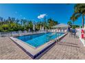 Community pool featuring a clear, inviting blue swimming pool with chairs, umbrellas, and palm trees at 5858 Gasparilla Rd # Mm40, Boca Grande, FL 33921