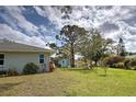 Expansive backyard with lush lawn, mature trees, shed, and room for outdoor activities at 587 Viridian St, Englewood, FL 34223