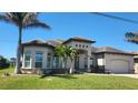 Elegant single-story home featuring a tile roof, arched windows, and lush tropical landscaping at 8144 Antwerp Cir, Port Charlotte, FL 33981