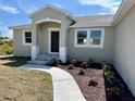 Charming single-story home featuring a landscaped yard and a welcoming front entrance at 9172 Ravel St, Port Charlotte, FL 33981