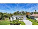 Inviting home exterior with manicured lawn, palm trees, and neutral tones blending with the landscape at 9350 Prospect Ave, Englewood, FL 34224