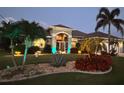 Inviting single-story home exterior with vibrant landscaping and a well-lit facade at twilight at 10082 Army Cir, Port Charlotte, FL 33981