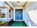 Covered entryway featuring a vibrant blue front door with decorative glass inserts at 10299 Willmington Blvd, Englewood, FL 34224