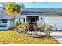 View of the home's well-maintained lawn and landscaping, including the mature palm tree at 10299 Willmington Blvd, Englewood, FL 34224