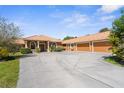 Beautiful home exterior with a spacious driveway leading to a three-car garage and lush landscaping at 103 Mecca St, Port Charlotte, FL 33954