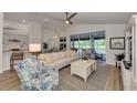 Open-concept living room featuring back patio access, kitchen, and coastal decor at 14236 Silver Lakes Cir, Port Charlotte, FL 33953