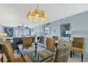 Bright dining room with modern light fixture, glass table and wicker chairs at 14459 River Beach Dr # 129, Port Charlotte, FL 33953