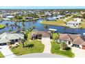 Aerial view of stunning waterfront home with lush landscaping, private dock, and beautiful water views at 15690 Viscount Cir, Port Charlotte, FL 33981