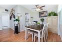 Cozy dining area with wood-look floors, a ceiling fan, and a view into the kitchen at 1680 Meadow Lark Ln, Englewood, FL 34224