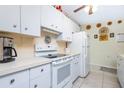 Bright kitchen features white appliances, tile floors, and ample cabinet space at 1680 Meadow Lark Ln, Englewood, FL 34224