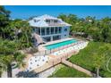 Beautiful backyard featuring a sparkling pool, a wooden walkway, and lush landscaping at 19 Grouper Hole Dr, Boca Grande, FL 33921