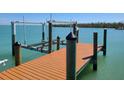 New wooden dock on calm waters with a boat lift at 19 Grouper Hole Dr, Boca Grande, FL 33921