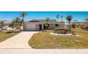 Inviting home features a manicured lawn, brick driveway, and attached garage at 1957 Arkansas Ave, Englewood, FL 34224