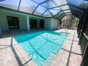 Beautiful backyard pool with a screened enclosure and tiled patio area at 220 Jennifer Dr, Rotonda West, FL 33947