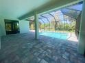 Covered patio overlooking a sparkling pool surrounded by lush greenery at 220 Jennifer Dr, Rotonda West, FL 33947