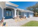 Inviting front entrance with double glass doors, stone accents, and manicured landscaping at 228 White Marsh Ln, Rotonda West, FL 33947