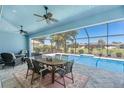 Screened lanai with dining area, ceiling fans, and view of the sparkling pool at 228 White Marsh Ln, Rotonda West, FL 33947
