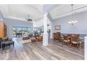 Open-concept living room with vaulted ceilings, wood floors, and stylish furnishings at 228 White Marsh Ln, Rotonda West, FL 33947