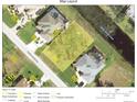 Aerial view of property lot surrounded by greenery, neighboring houses, and a creek at 254 White Marsh Ln, Rotonda West, FL 33947