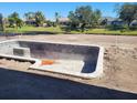 An empty in-ground pool in backyard under construction with a blue sky overhead at 254 White Marsh Ln, Rotonda West, FL 33947