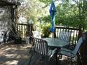 Outdoor patio furniture set with umbrella on a wooden deck surrounded by trees at 26191 Angelica Rd, Punta Gorda, FL 33955