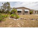 Tan home featuring tidy front lawn, landscaping and stone bordered flower bed at 3021 Holly Ave, Englewood, FL 34224