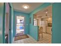 Bright entryway leads into a kitchen with white cabinets and appliances, featuring a sunny atmosphere at 405 Pine Hollow Cir # 405, Englewood, FL 34223