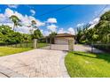 Close up of circular paver driveway and decorative fencing with a view of the home in the background at 4238 Golfair Ln, North Port, FL 34288