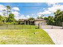 Lovely home features an expansive lawn, decorative fencing, and a circular paver driveway at 4238 Golfair Ln, North Port, FL 34288