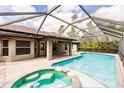 Screened-in pool with attached jacuzzi tub and covered patio at 4238 Golfair Ln, North Port, FL 34288