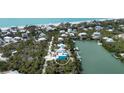 Aerial view of the home's location, surrounded by water, palm trees, and other houses at 50 Tarpon Way, Placida, FL 33946