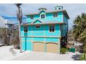 Charming stilt home with two-car garage, turquoise siding and staircase access at 50 Tarpon Way, Placida, FL 33946