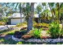 Charming front yard with vibrant landscaping, a brick-lined flowerbed, and a well-maintained lawn at 745 Sesame St, Englewood, FL 34223