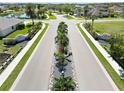 Landscaped entrance to the community with sidewalks, palm trees, and well-maintained lawns at 8784 Mystic Cir, North Port, FL 34287