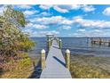 Scenic view of a dock extending into the water, complemented by a bright sky with fluffy clouds and distant structures at 9 Peekins Cove Dr, Boca Grande, FL 33921