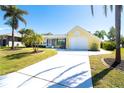 Inviting home with a freshly painted driveway, bright exterior, and landscaping, offering a welcoming entrance at 9330 Migue Cir, Port Charlotte, FL 33981