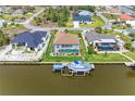 A canal-front home with a pool, boat dock, and lush green landscaping at 10640 Ayear Rd, Port Charlotte, FL 33981