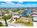 Breathtaking aerial view of a coastal community featuring waterfront homes along canals under a partly cloudy sky at 14810 Ingraham Blvd, Port Charlotte, FL 33981