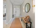Inviting entryway with neutral decor, stylish mirror, and convenient bench seating at 1607 Laurel Brook Ln, Port Charlotte, FL 33953