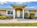 Charming front entrance with seating area, decorative wreath, and manicured landscaping at 182 Rotonda W Blvd # B, Rotonda West, FL 33947
