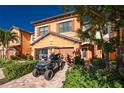 Two-story home showcasing a brick paver driveway, mature landscaping, and a convenient golf cart at 20231 Lagente Cir, Venice, FL 34293