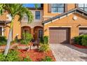 Inviting home exterior with arched entryway, lush garden, and beautiful brick driveway at 20279 Lagente Cir, Venice, FL 34293