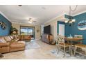 Bright living room with tile floors, leather sofa, flat-screen TV, and sliding glass doors to a patio at 20279 Lagente Cir, Venice, FL 34293