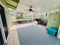 Spacious covered backyard patio with ceiling fan, offering shade and comfort for outdoor relaxation and entertainment at 2985 N Beach Rd # Bv-5, Englewood, FL 34223