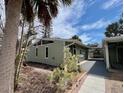 View of the home's exterior with painted light green siding, featuring a well-maintained yard and a covered carport at 2985 N Beach Rd # Bv-5, Englewood, FL 34223