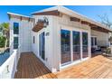 View of a wooden deck featuring a seating area, white railing, and sliding glass doors at 4078 N Beach Rd, Englewood, FL 34223