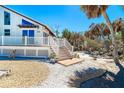 Exterior of beach home showing deck, stairs, landscaping and home's facade at 4078 N Beach Rd, Englewood, FL 34223