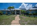 Beautiful home with a stone pathway, lush green lawn, and meticulously maintained landscaping at 50 Spyglass Aly, Placida, FL 33946