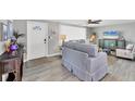 Inviting living room with wood-look tile floors, a ceiling fan, and comfortable seating at 6035 Manasota Key Rd, Englewood, FL 34223